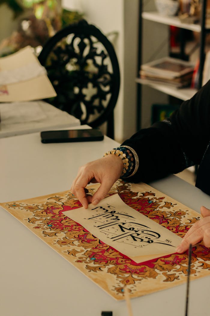 Detailed view of a woman practicing Arabic calligraphy with decorative borders.